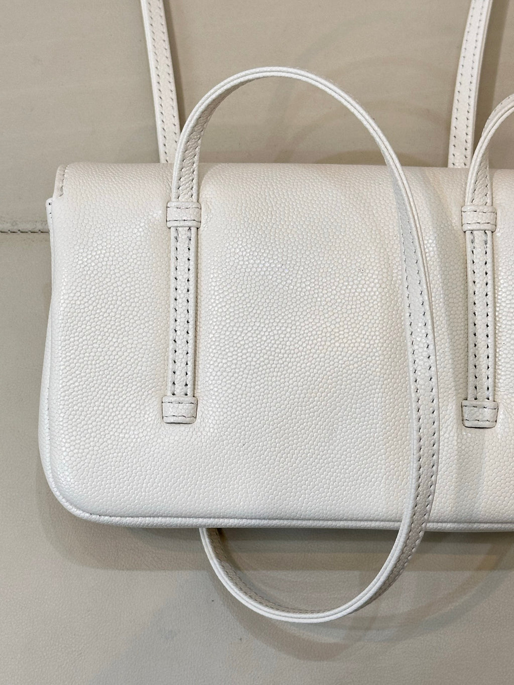Chanel white leather mini handbag close-up with textured grain and two handle straps