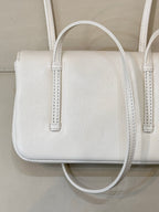 Chanel white leather mini handbag close-up with textured grain and two handle straps