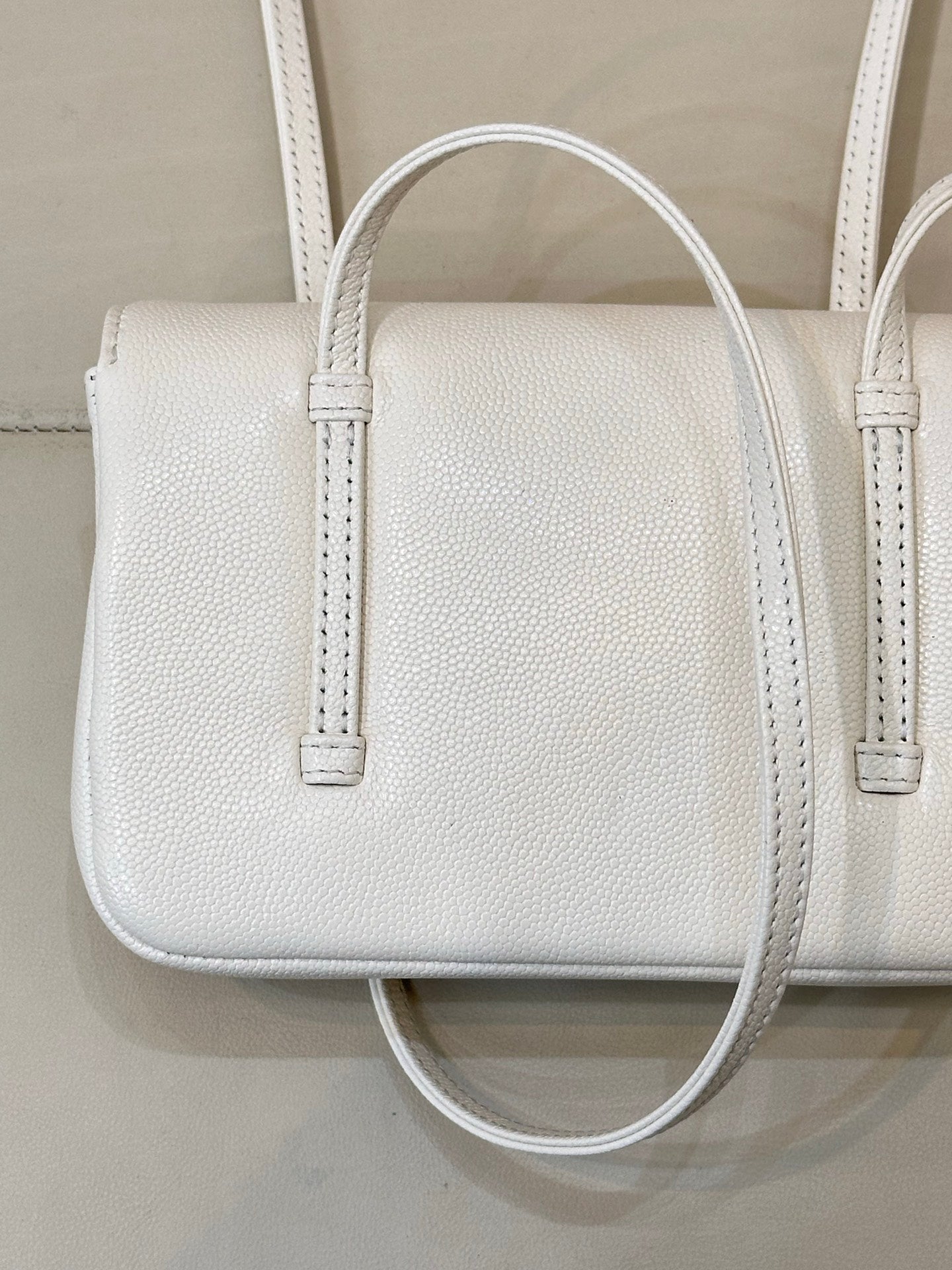 Chanel white leather mini handbag close-up with textured grain and two handle straps