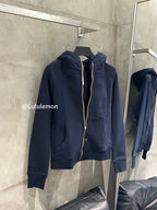 Navy zip-up hoodie on hanger with hood and gold zipper trim, front view