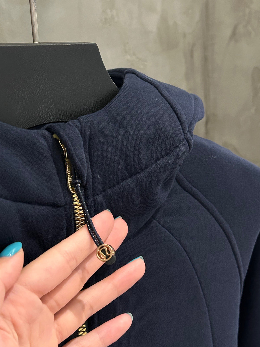 Navy hoodie zipper pull with gold ring and front gold-trim zipper