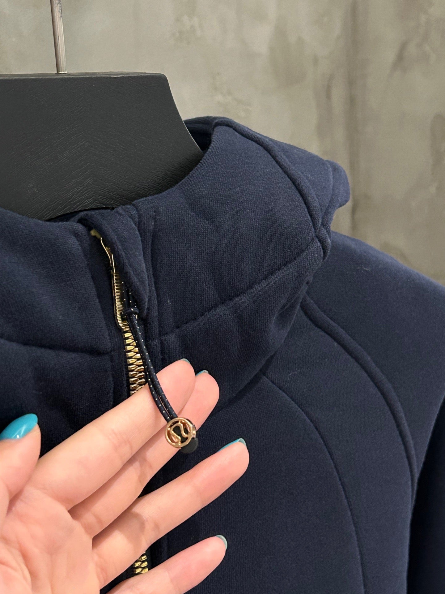 Navy hoodie zipper pull with gold ring and front gold-trim zipper
