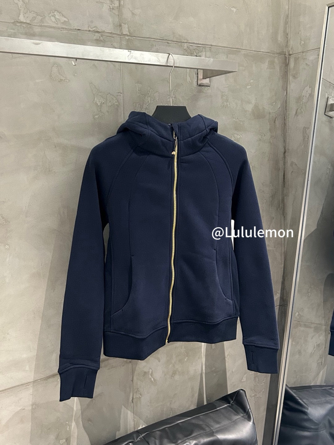 Navy hooded zip-up jacket with gold zipper and front kangaroo pocket