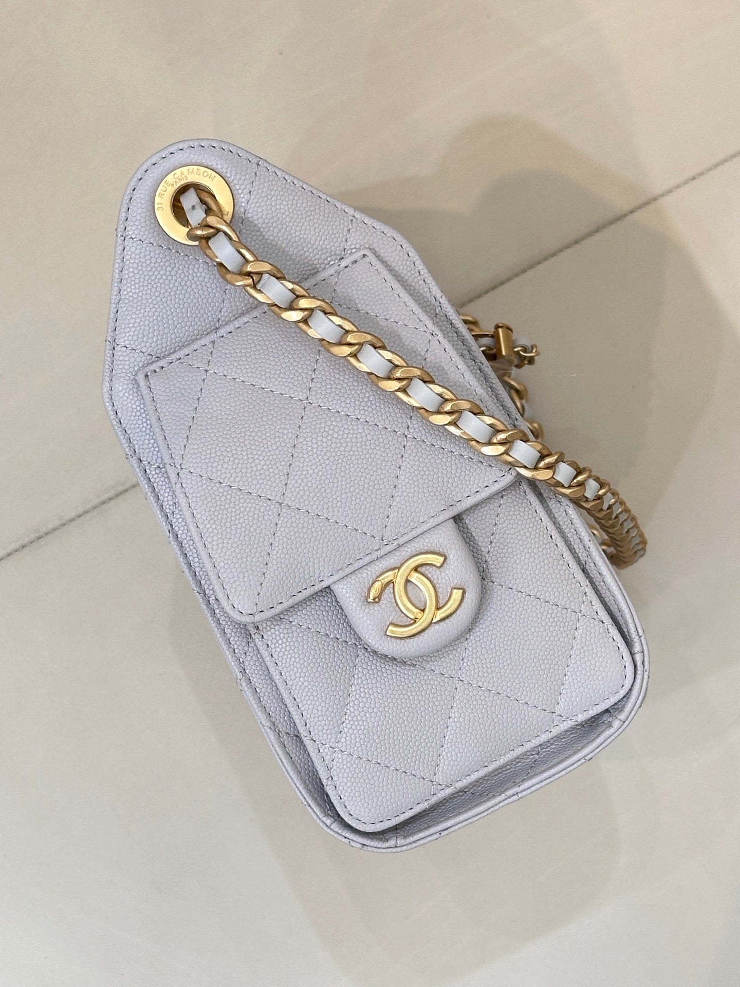 Light blue quilted mini shoulder bag with gold chain strap and Chanel logo emblem