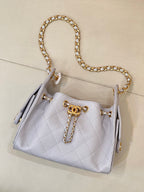 Light blue quilted handbag with gold chain shoulder strap and tassel-like side details