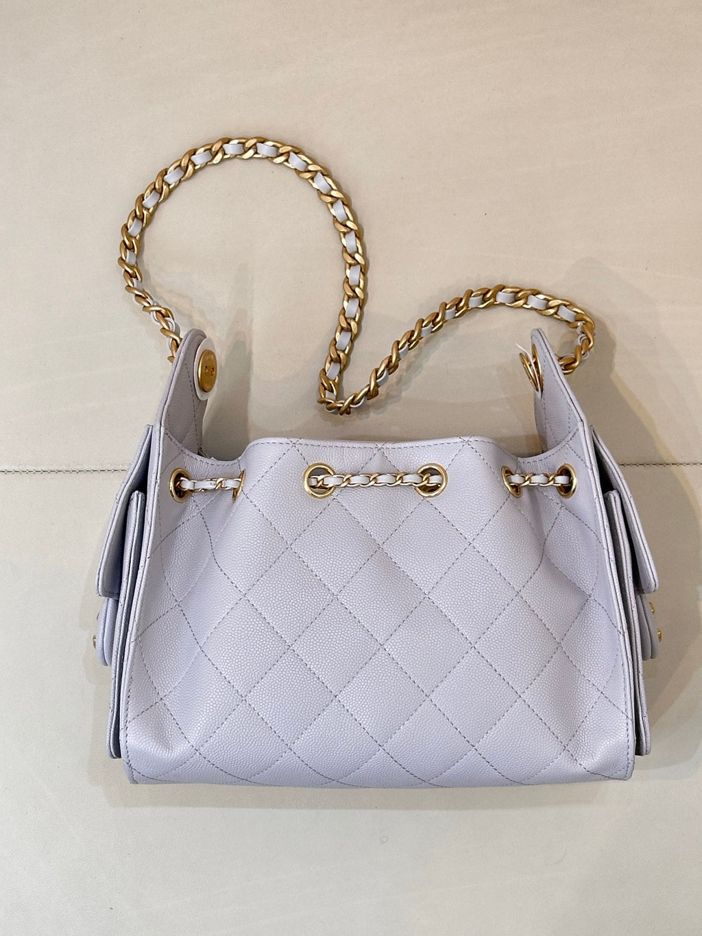 Light blue quilted handbag with gold chain shoulder straps and gold-toned hardware accents