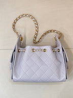 Light blue quilted handbag with gold chain shoulder straps and gold-toned hardware accents