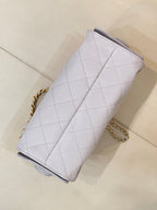 Light blue quilted handbag viewed from side, with gold chain strap and top edge