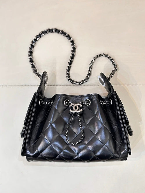Chanel quilted black handbag with chain shoulder straps and top handle, metal closure hardware