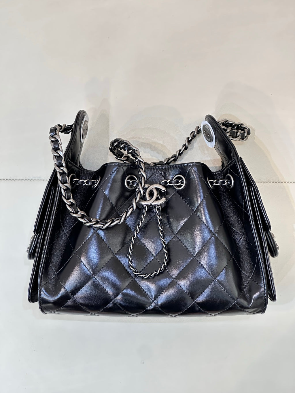 Chanel quilted black handbag with chain handle and shoulder straps, metal rings on front