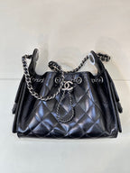 Chanel quilted black handbag with chain handle and shoulder straps, metal rings on front