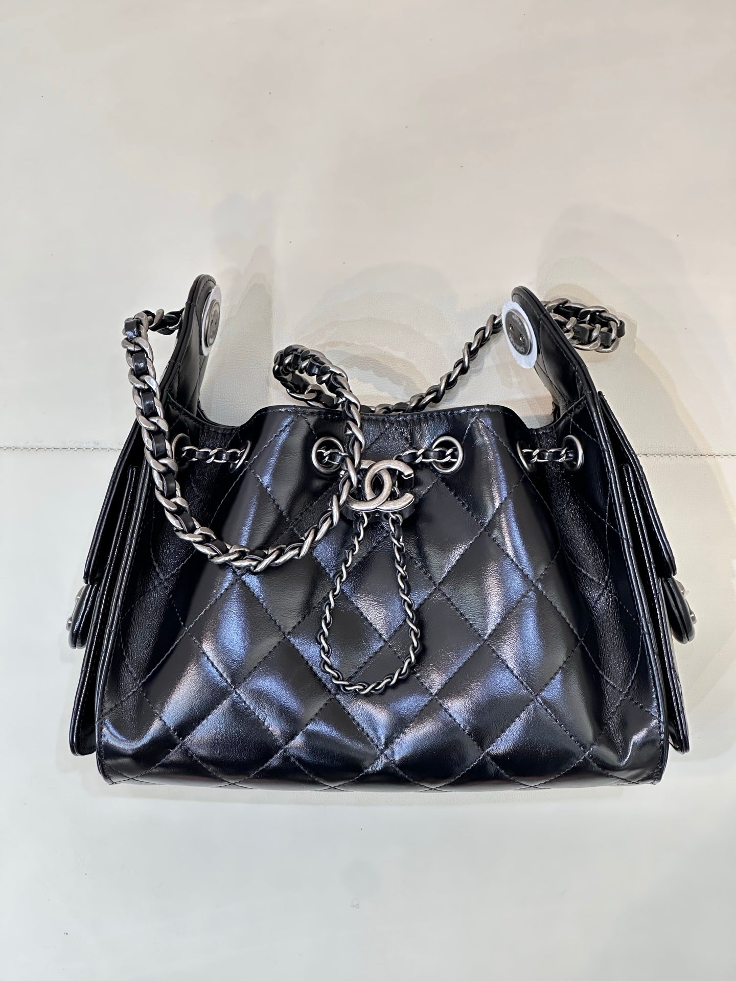 Chanel quilted black handbag with chain handle and shoulder straps, metal rings on front