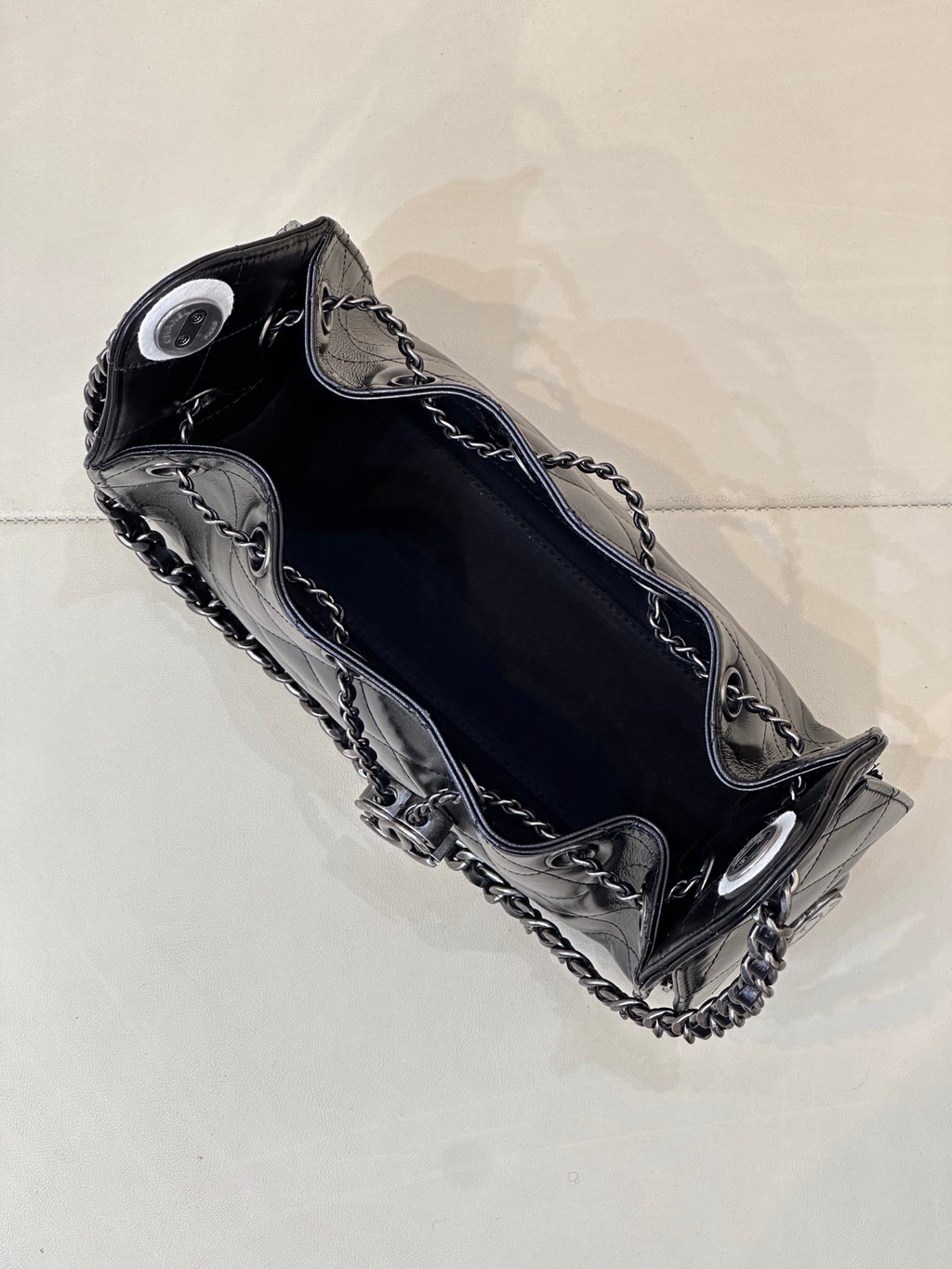 Chanel quilted black handbag top view with chain shoulder strap and metal hardware accents