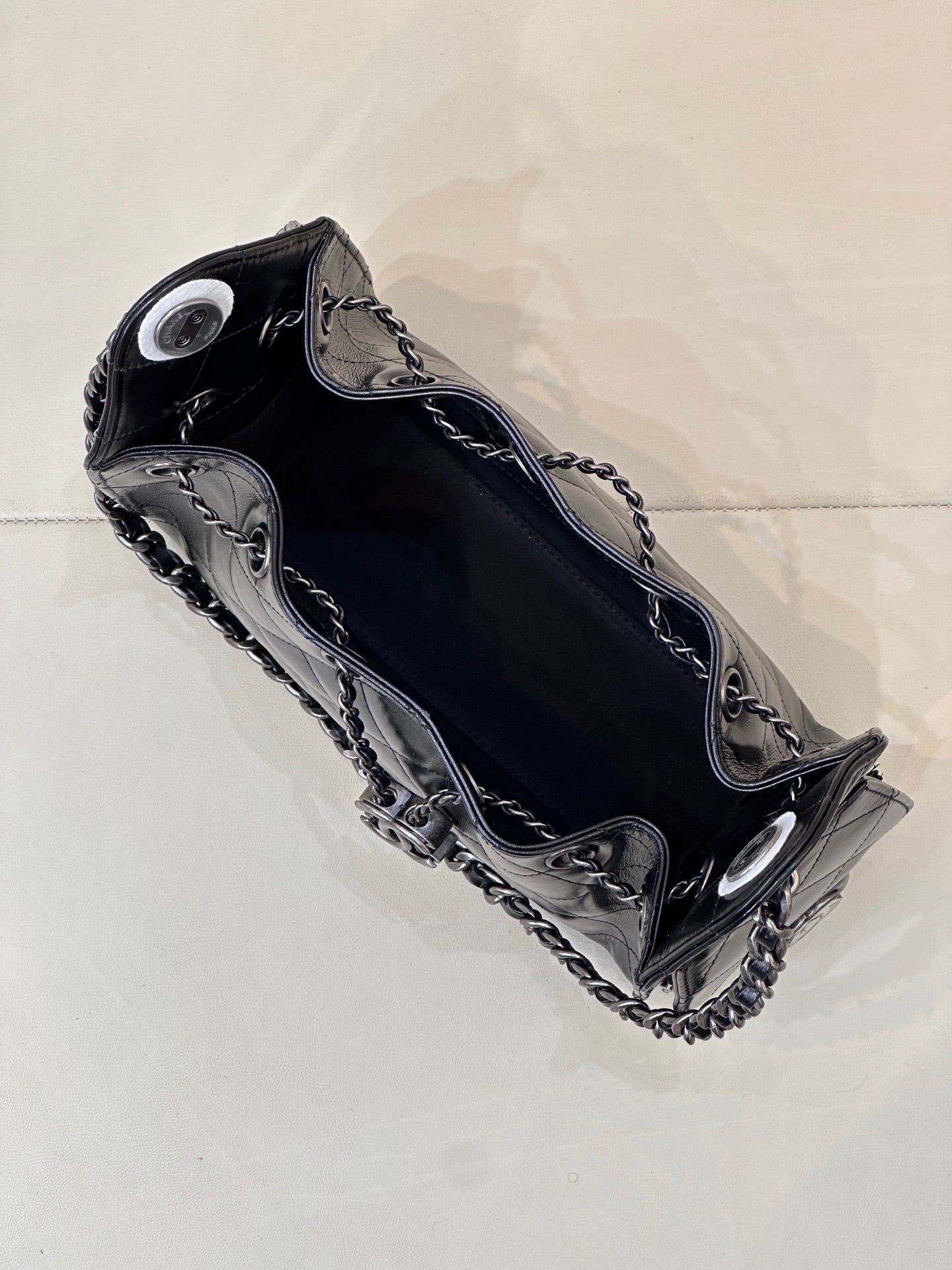 Chanel quilted black handbag top view with chain shoulder strap and metal hardware accents