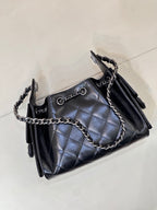 Chanel quilted black handbag angled view with chain strap and front metal ring clasp
