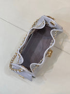 Light blue quilted handbag open view with gold chain trim and inner lining