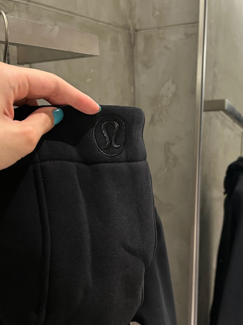 Black hoodie sleeve with small logo emblem near shoulder