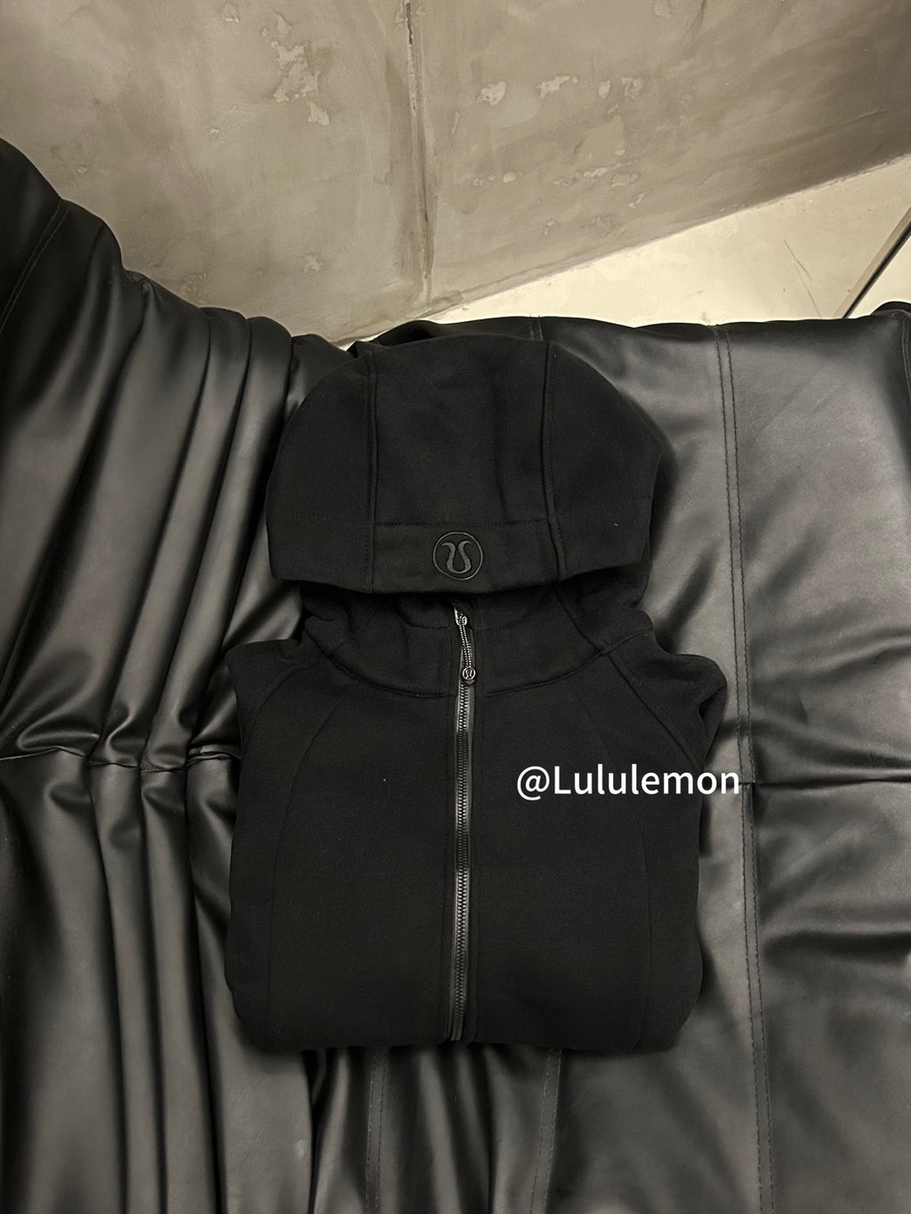 Black hooded zip-up jacket with kangaroo pocket, folded