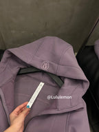 Lavender hooded jacket close-up with logo patch and care label