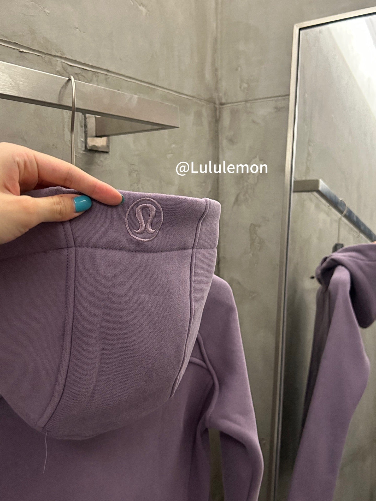 Lavender hooded jacket with circular logo patch on hood trim