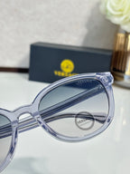 Versace sunglasses close-up: clear frame with branding on the temple.