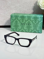 Gucci eyeglasses with black-and-tortoiseshell frames and clear lenses; green logo case.