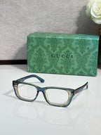 Gucci eyeglasses with dark frames and light blue temple accents; green logo case.