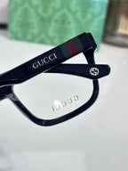 Gucci eyeglass hinge with web logo on dark temple, clear lens