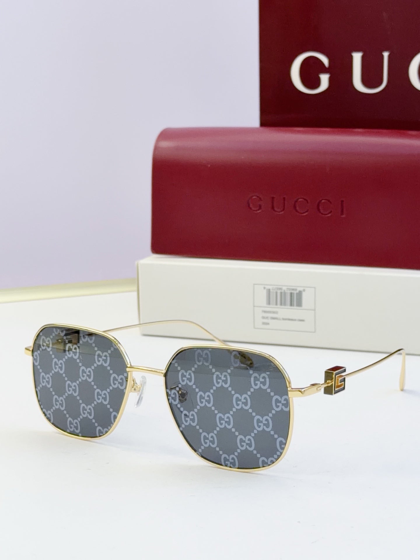 Round metal sunglasses with gold frame and GG-pattern dark lenses