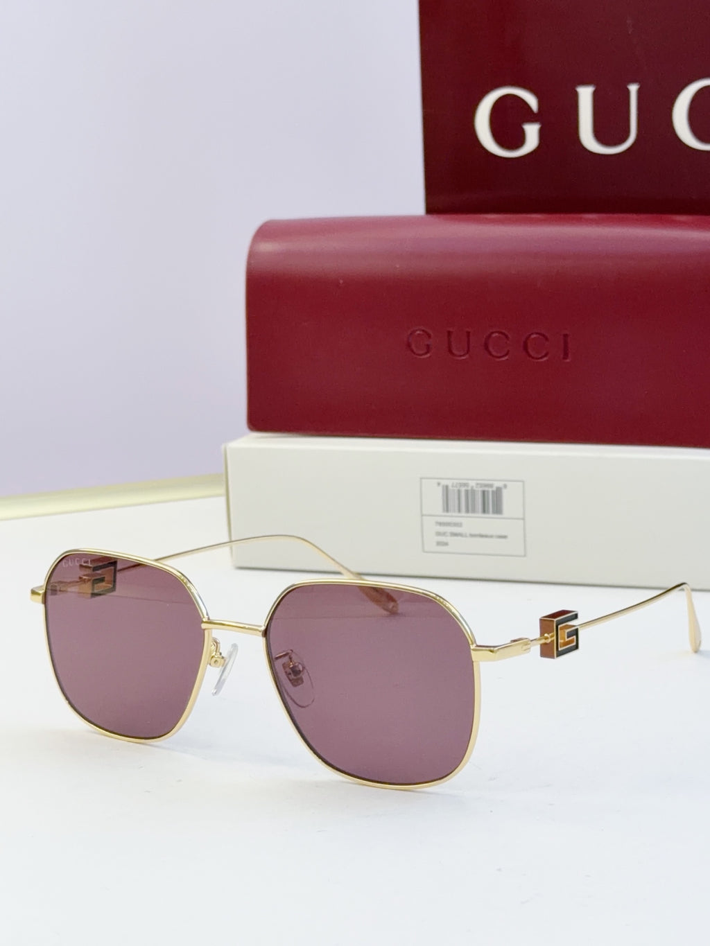 Round metal sunglasses with gold frame and purple tinted lenses