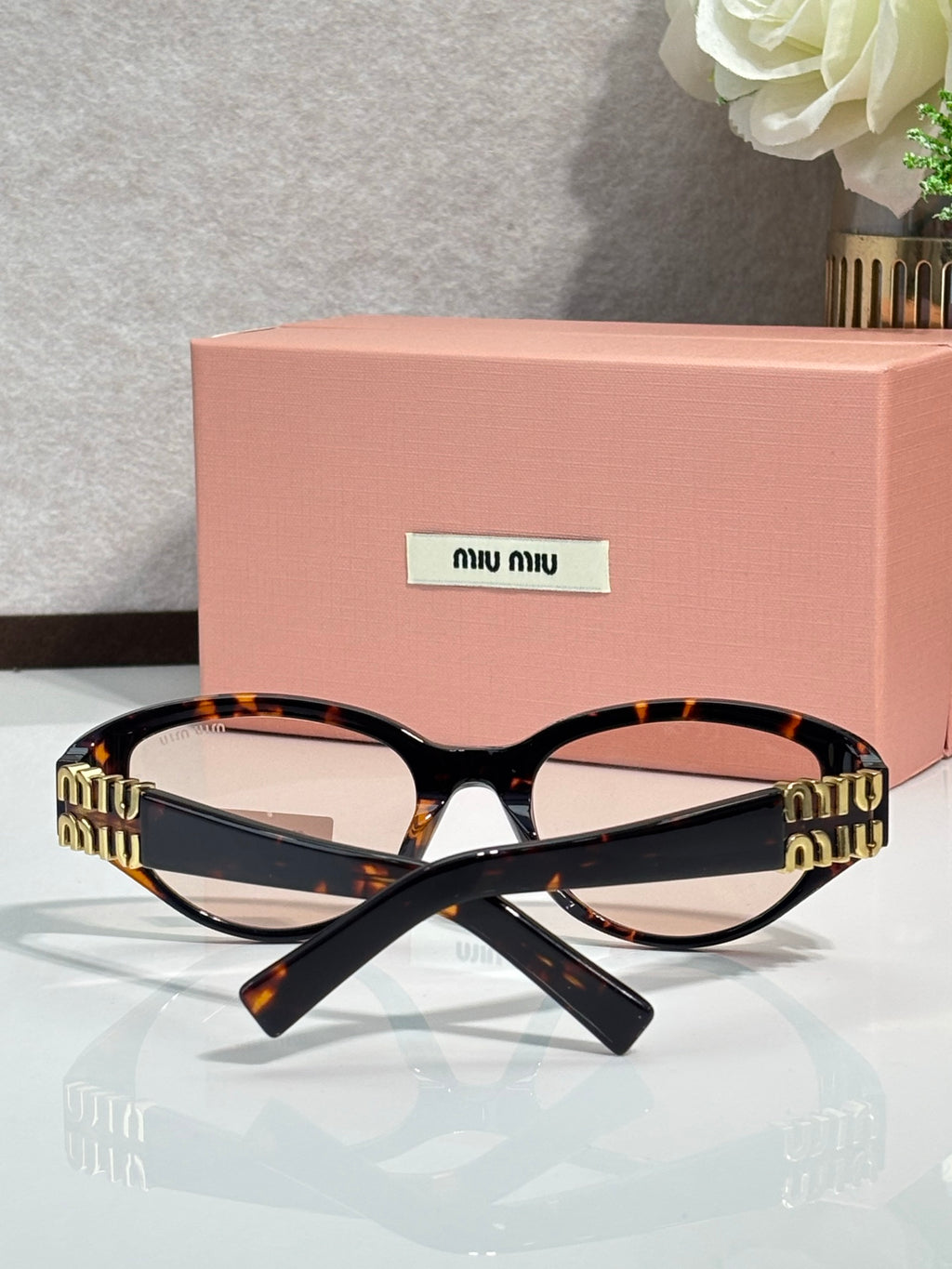Tortoise cat-eye sunglasses with dark lenses and gold-tone logo arms