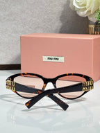 Tortoise cat-eye sunglasses with dark lenses and gold-tone logo arms