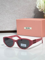 Red cat-eye sunglasses with dark lenses and gold-tone logo temple arms