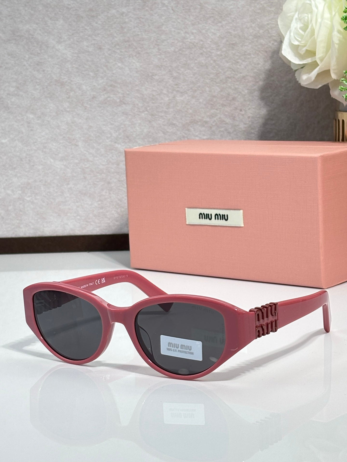 Red cat-eye sunglasses with dark lenses and gold-tone logo temple arms