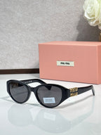 Black cat-eye sunglasses with dark lenses and gold-tone logo arms