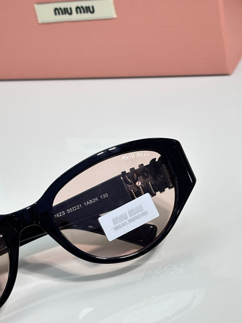 Black cat-eye sunglasses close-up of temple and lens markings