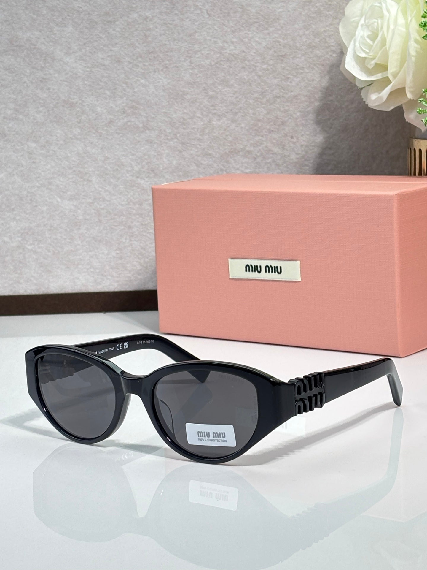 Black cat-eye sunglasses with dark lenses and ribbed gold-tone temple arms
