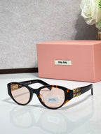 Tortoise-frame cat-eye sunglasses with dark lenses and gold-tone logo temples
