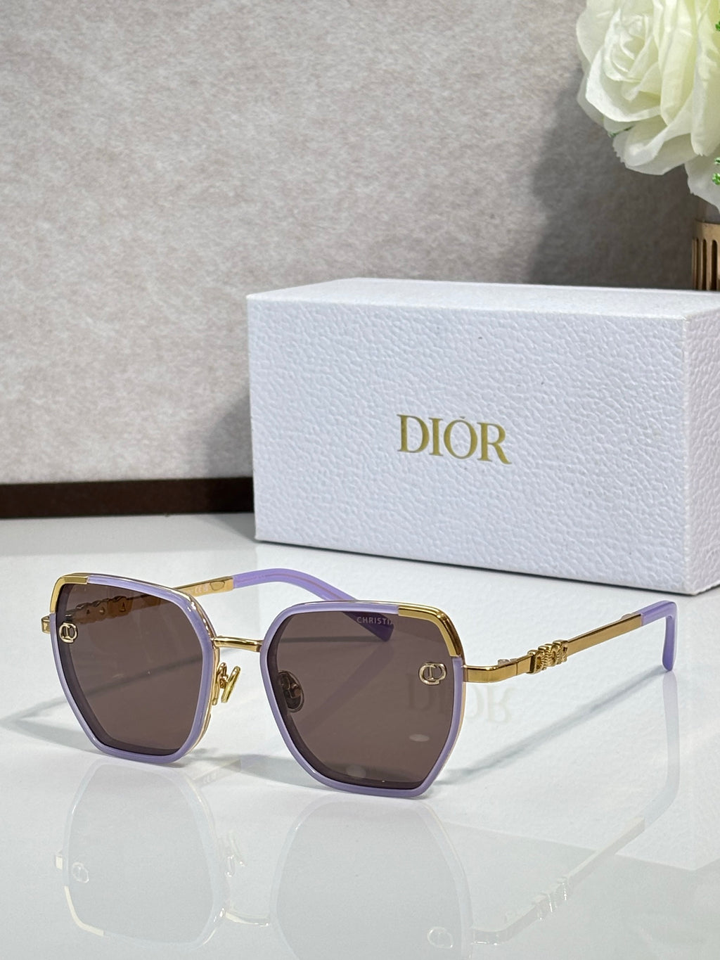 Dior sunglasses with purple-tinted lenses and gold-tone oversized square frames