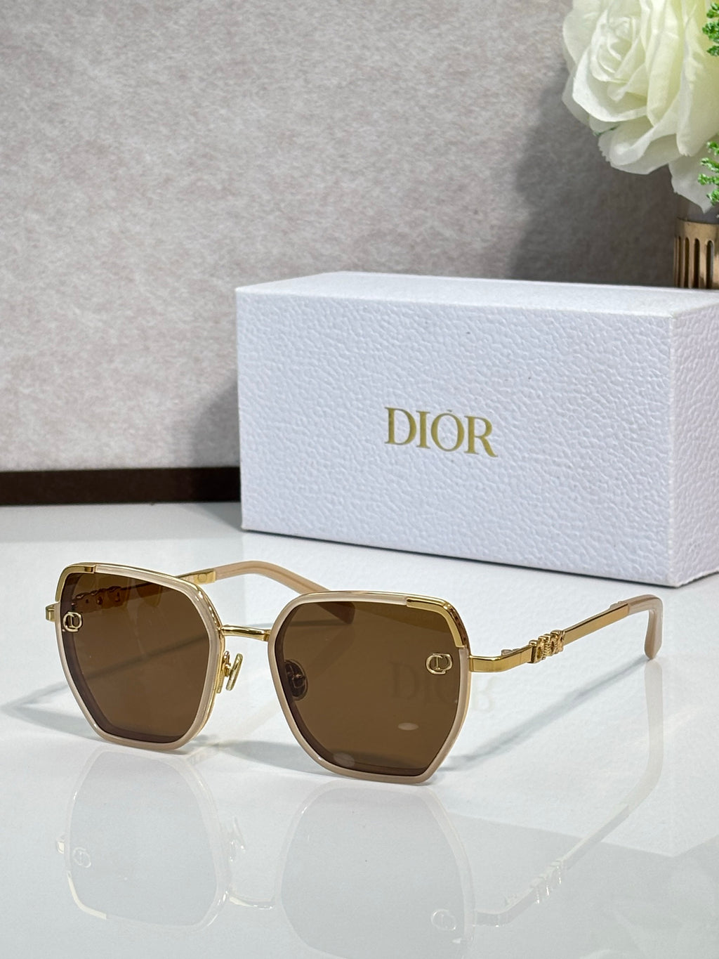 Dior sunglasses with brown-tinted lenses and gold-tone oversized square frames