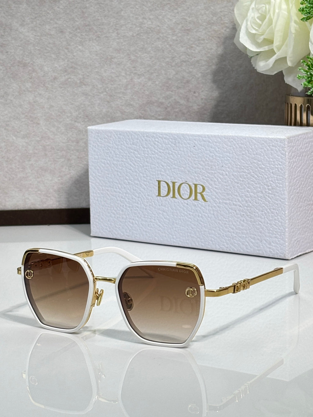 Dior sunglasses with brown-tinted lenses and white-trimmed gold-tone square frames