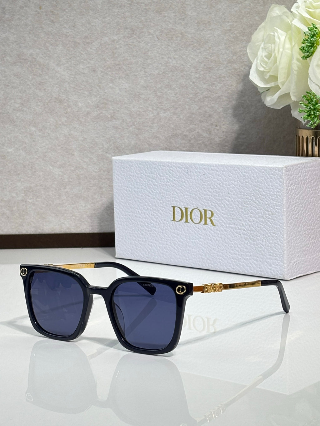Sunglasses by Dior with dark frames, dark lenses, and gold temple accents