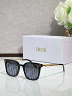 Sunglasses by Dior with black frames, patterned lenses, and gold temple details