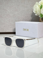 Sunglasses by Dior with white frames and dark lenses, with gold temple accents