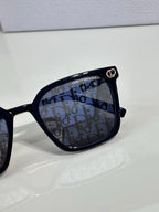 Sunglasses by Dior close-up with black frames and logo-printed dark lenses