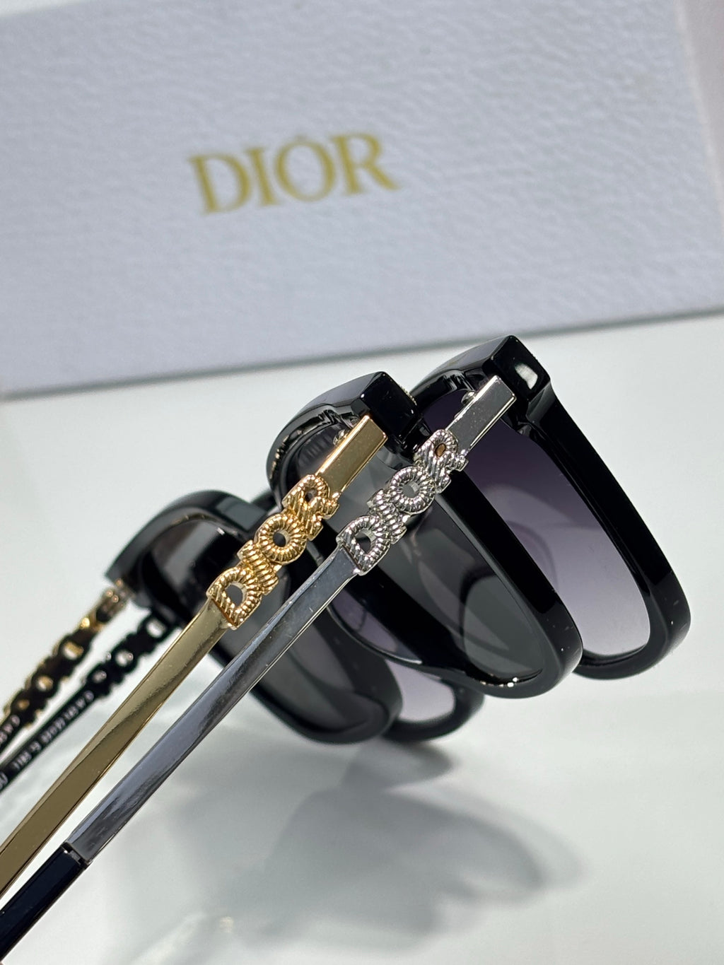 Sunglasses by Dior close-up with gold-and-silver chain temple details