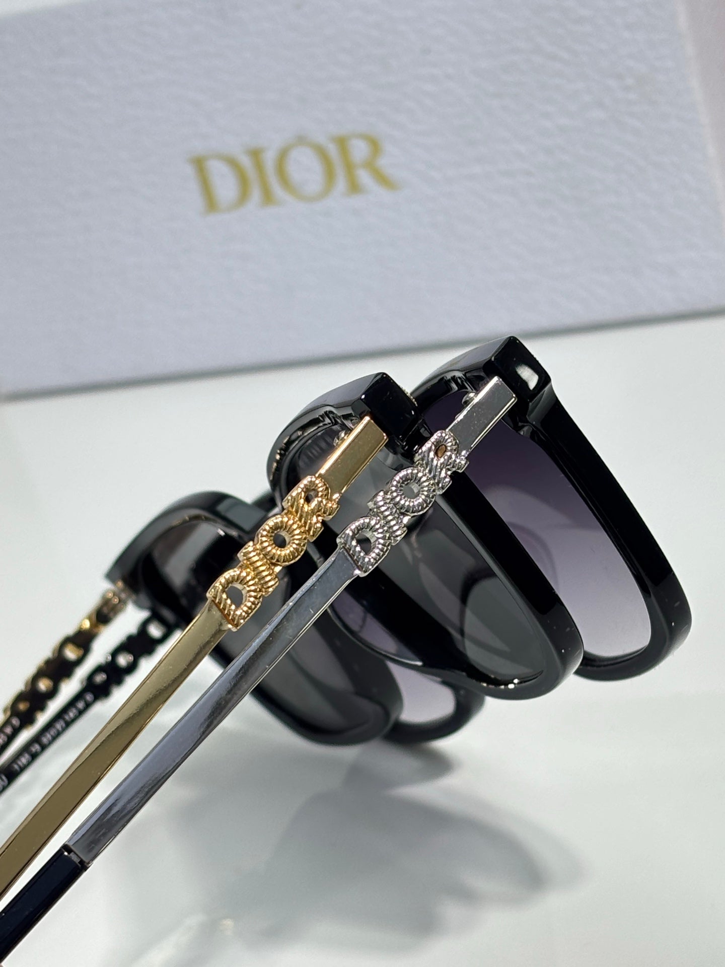 Sunglasses by Dior close-up with gold-and-silver chain temple details