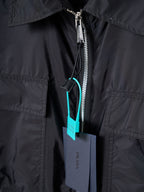 Prada dark jacket close-up of front zipper and pocket trim
