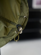 Olive green Prada jacket hem drawcord with metal eyelet and round charm