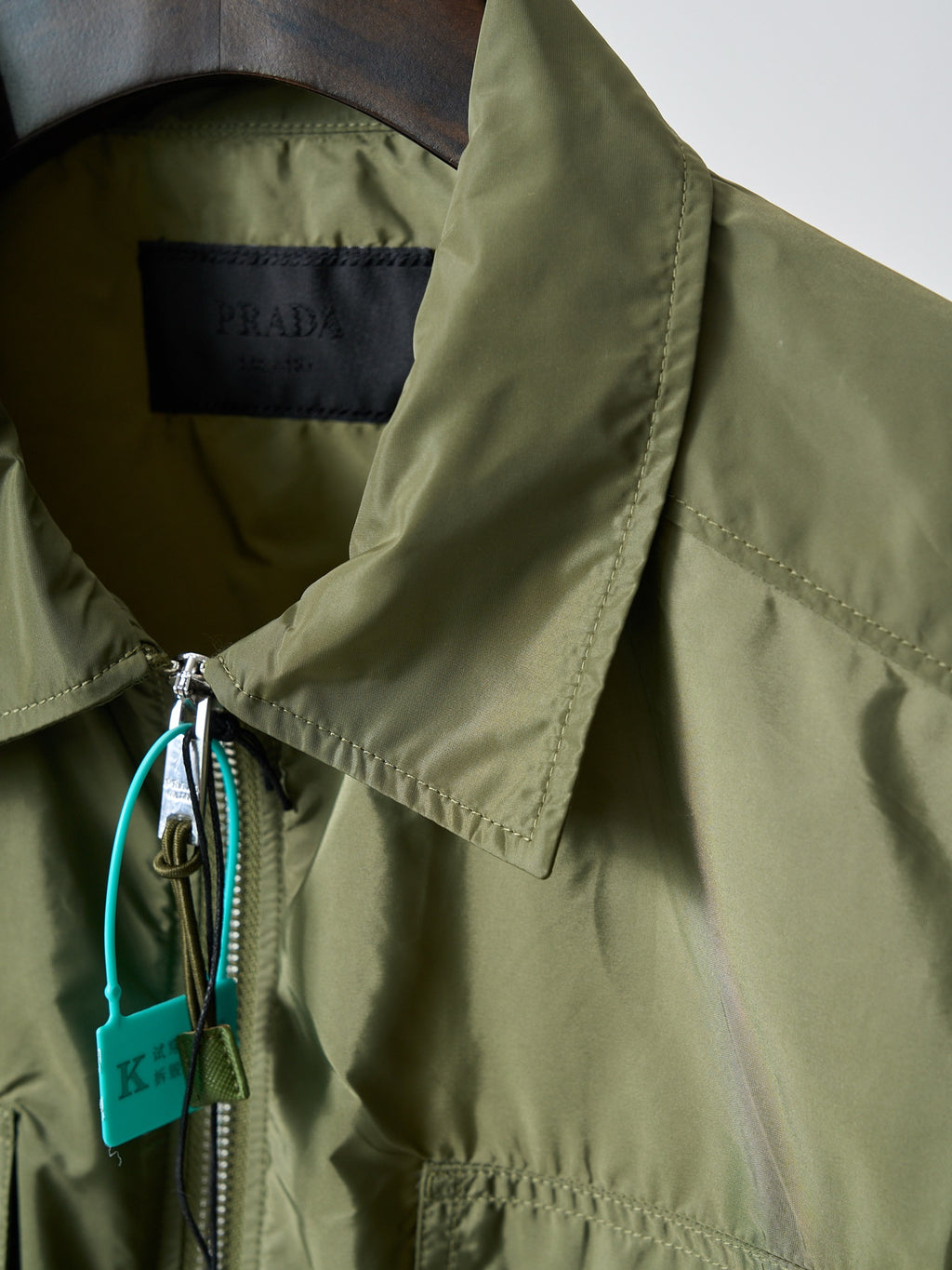 Olive green Prada jacket sleeve cuff with drawstring and turquoise tag detail